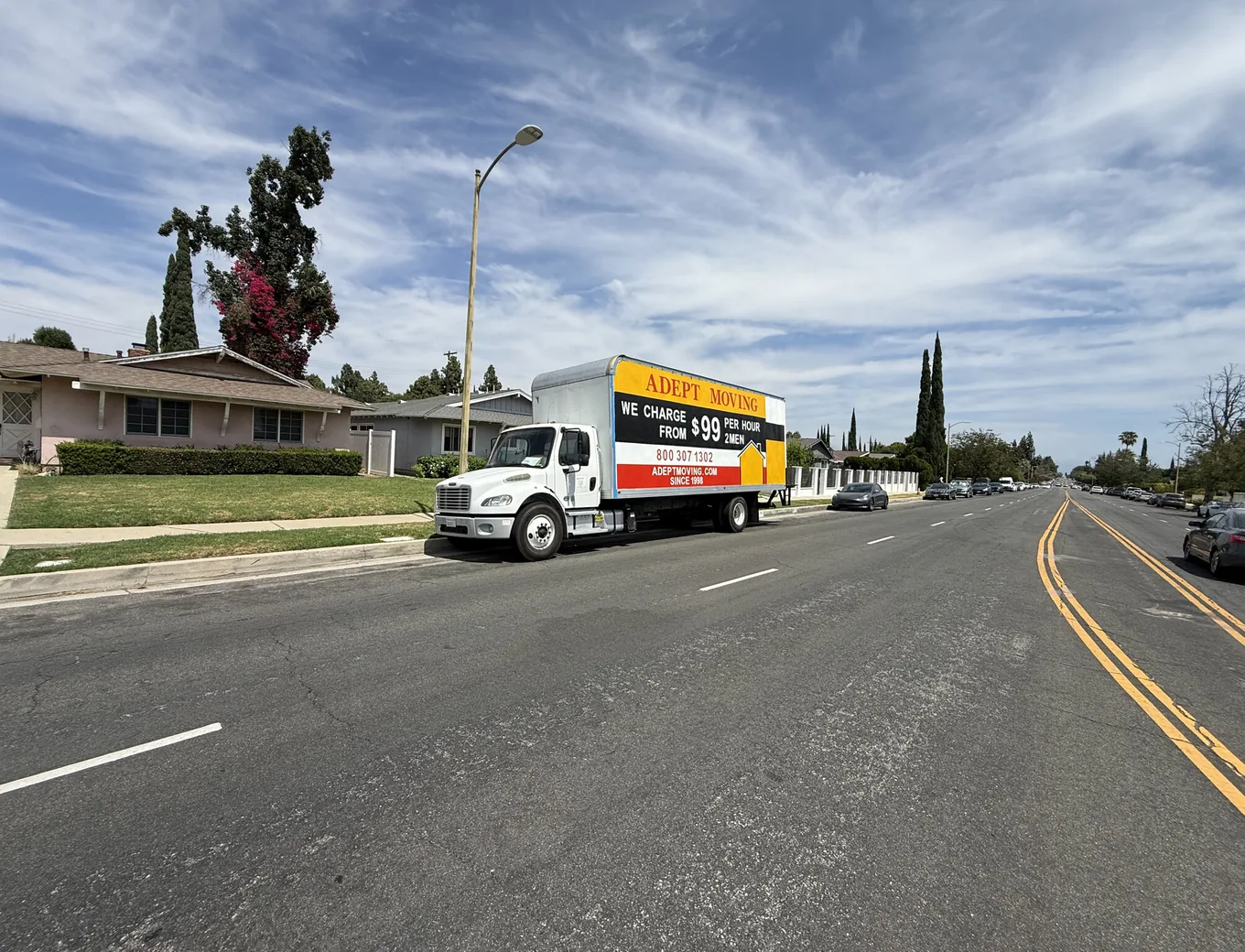 Adept Moving truck parked on a wide residential street with ranch homes in Chatsworth