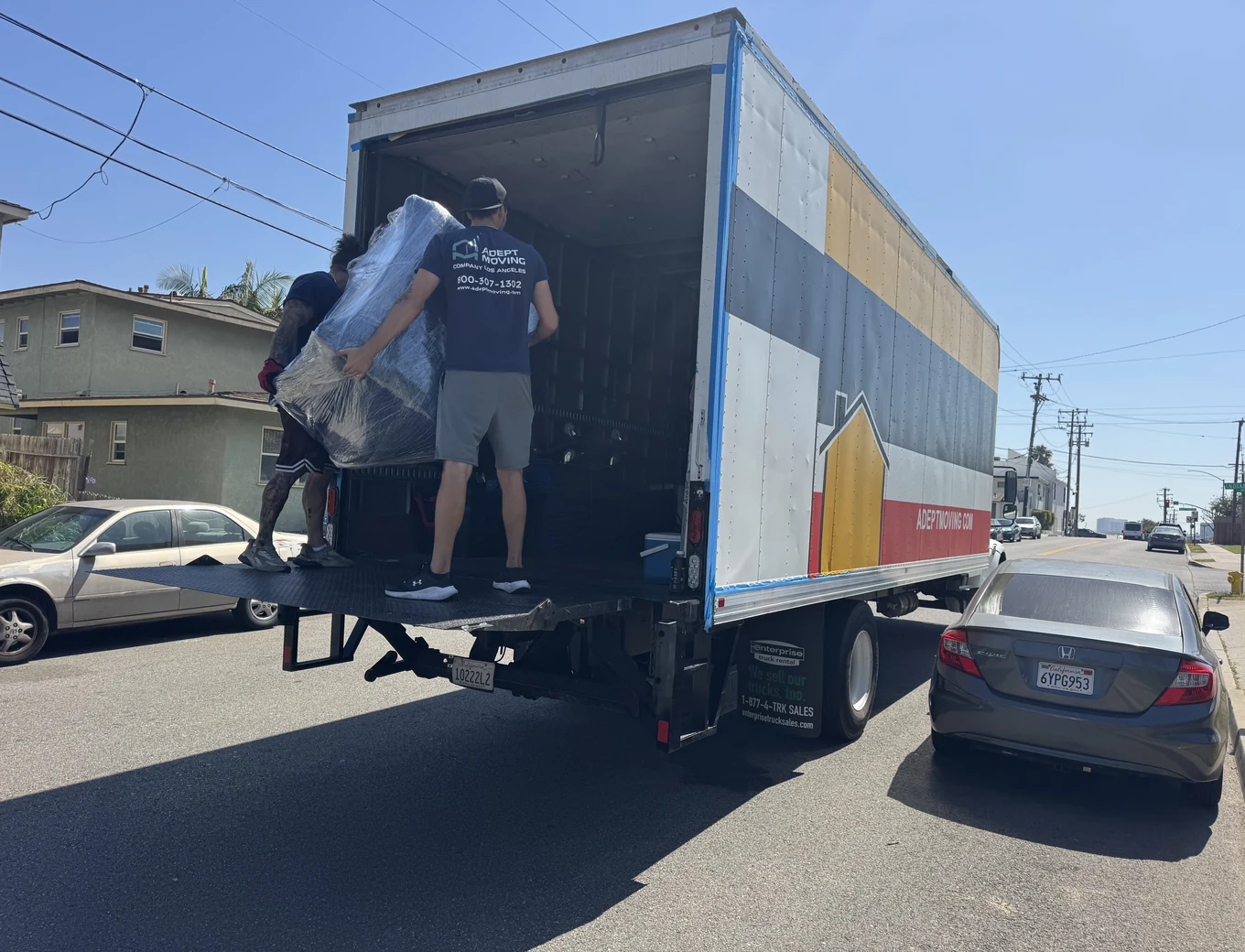 Two Adept movers loading a wrapped piece onto the liftgate on East Maple Avenue in El Segundo, 90245