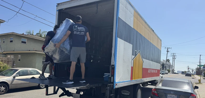Two Adept movers loading a wrapped piece onto the liftgate on East Maple Avenue in El Segundo, 90245