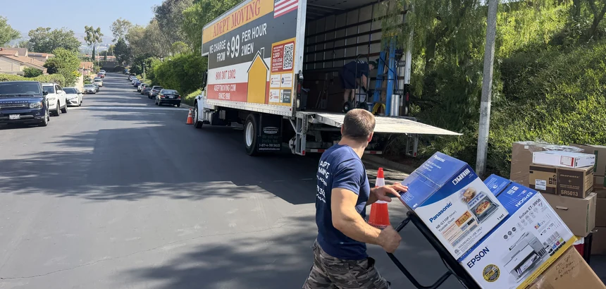 Adept mover wheeling boxed items on a hand truck on East Gingerwood Circle in Fullerton, 92835
