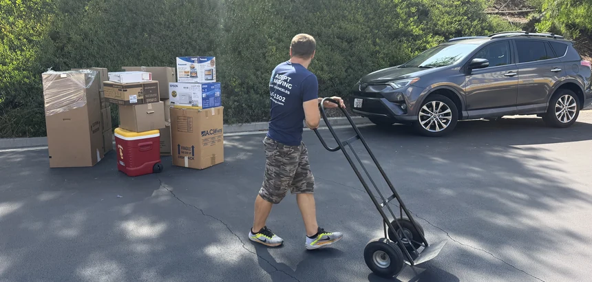 Adept mover with a hand truck beside staged boxes on East Gingerwood Circle in Fullerton, 92835