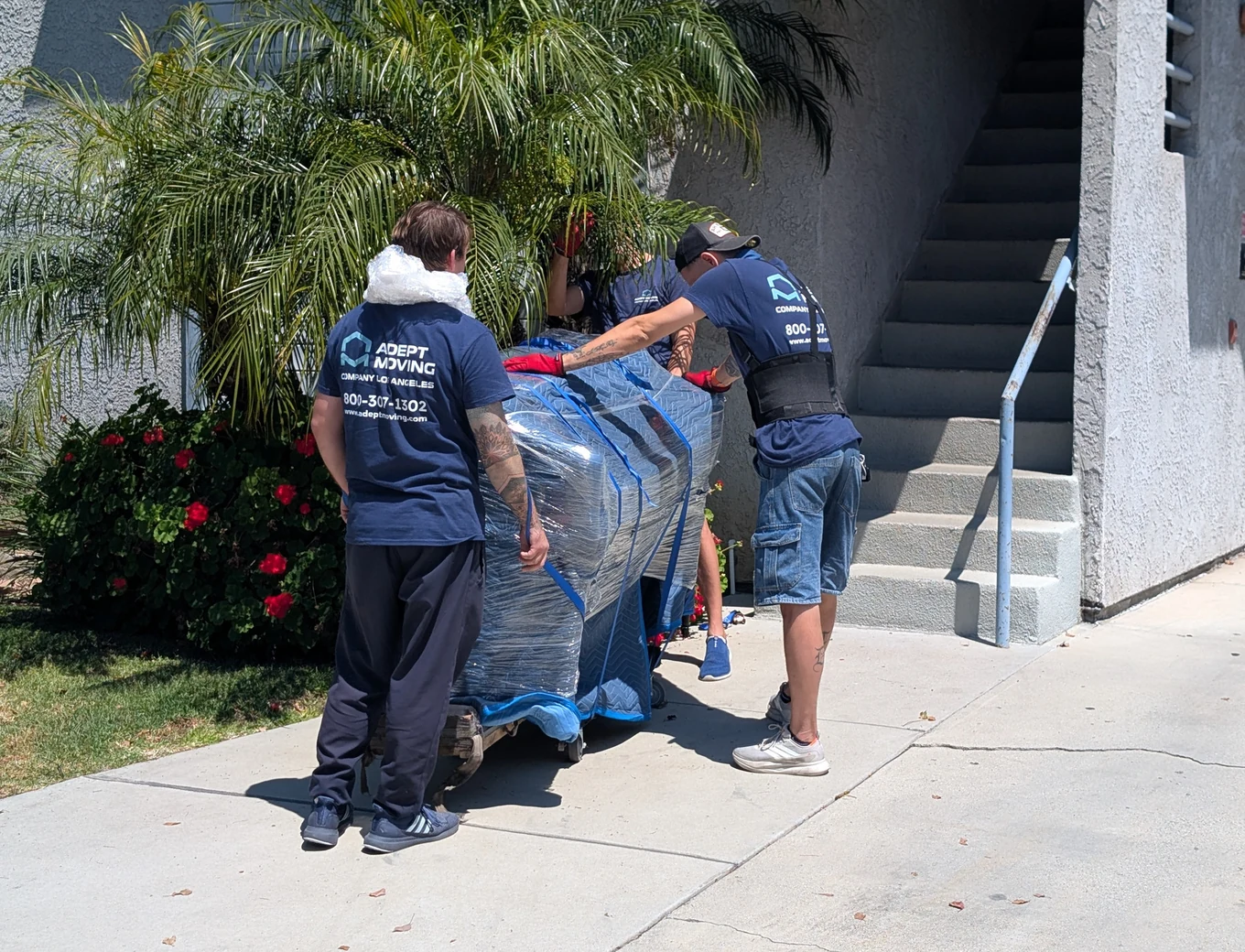 Adept Moving crew carrying shrink-wrapped furniture at an apartment on West Wilson Avenue in Glendale, 91203
