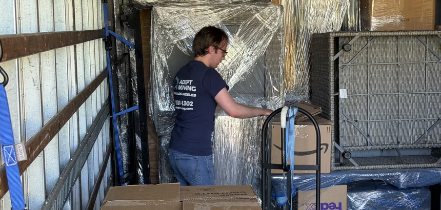 Adept mover inside a loaded moving truck with wrapped furniture and cartons on Mayapan Road in La Habra Heights, 90631