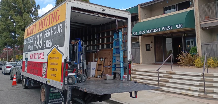 Adept Moving branded truck loading at a building with a dolly in Los Angeles, 90025