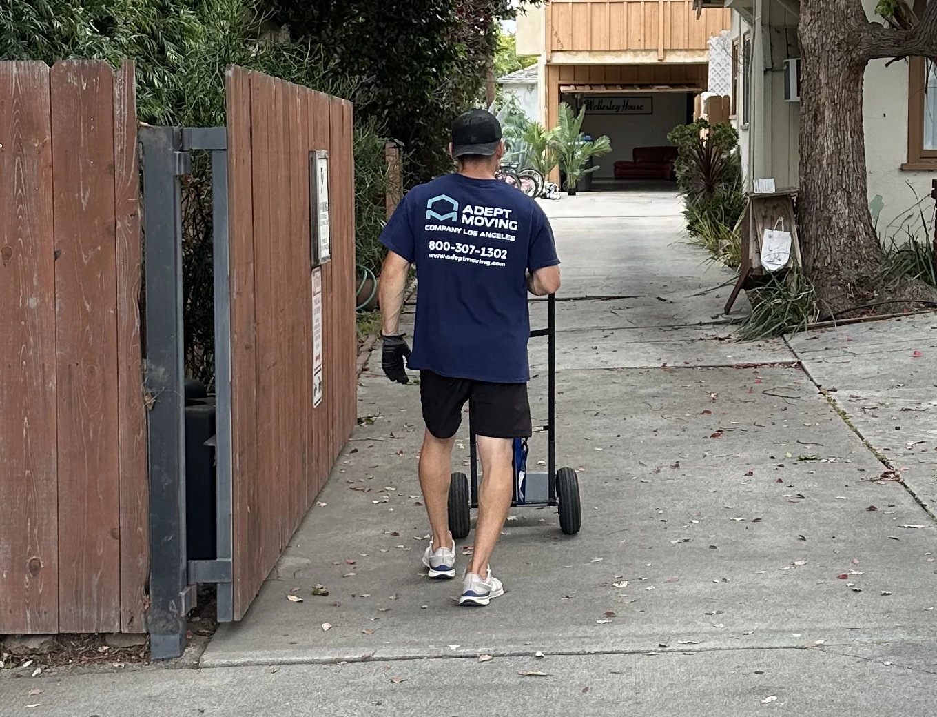 Adept mover moving items on a hand truck up a driveway on Wellesley Avenue in Los Angeles, 90025