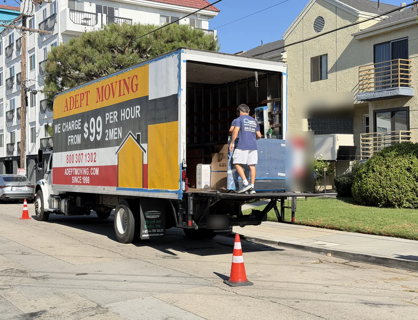 Adept Moving truck at the curb by an apartment building on Morrison Street in North Hollywood, 91601