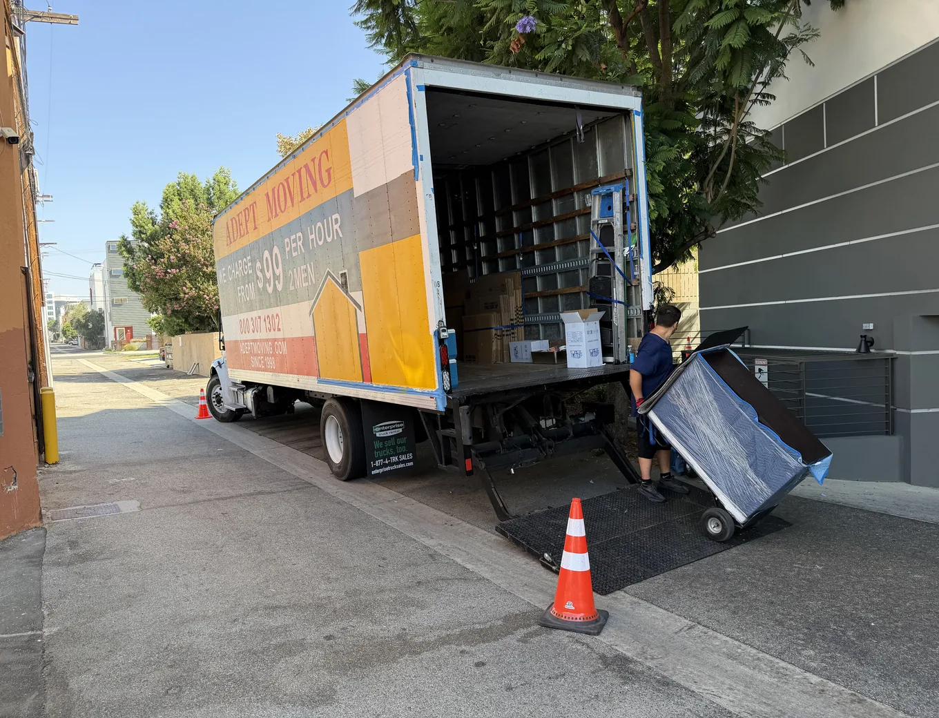 Adept Moving mover unloading wrapped furniture in an alley off Lankershim Boulevard in North Hollywood
