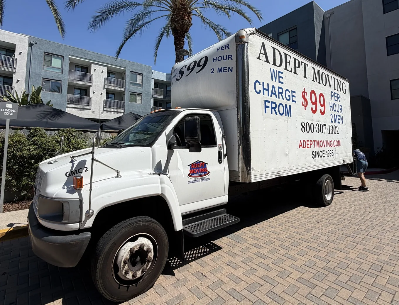 Adept Moving 18-foot truck on the paved entry drive of an apartment community on Corbin Avenue in Northridge