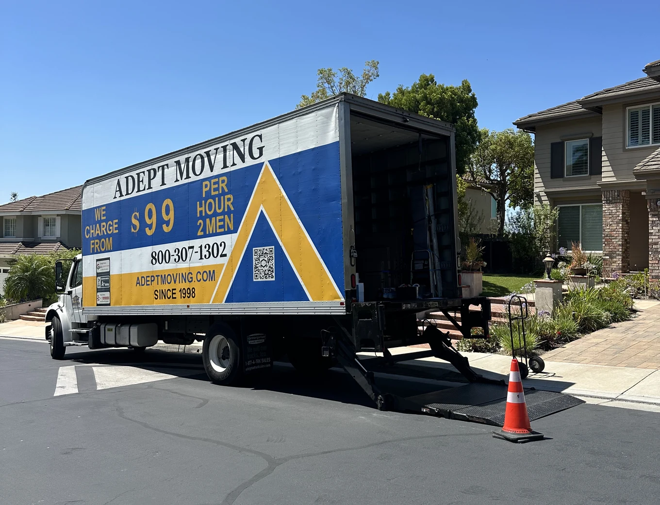 Adept Moving $99 branded box truck, side view with the liftgate down, on East Hollyoak Ridge in Orange, 92867