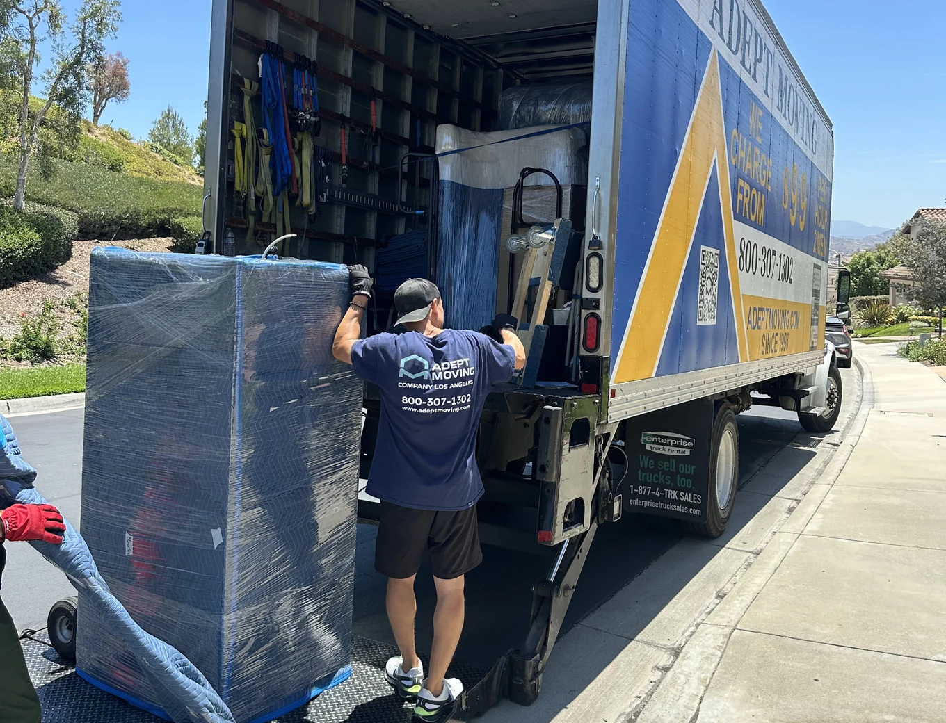 Adept mover loading a blanket-wrapped piece onto the truck liftgate on East Hollyoak Ridge in Orange, 92867