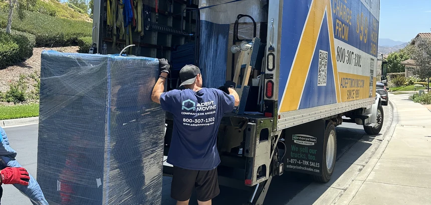 Adept mover loading a blanket-wrapped piece onto the truck liftgate on East Hollyoak Ridge in Orange, 92867