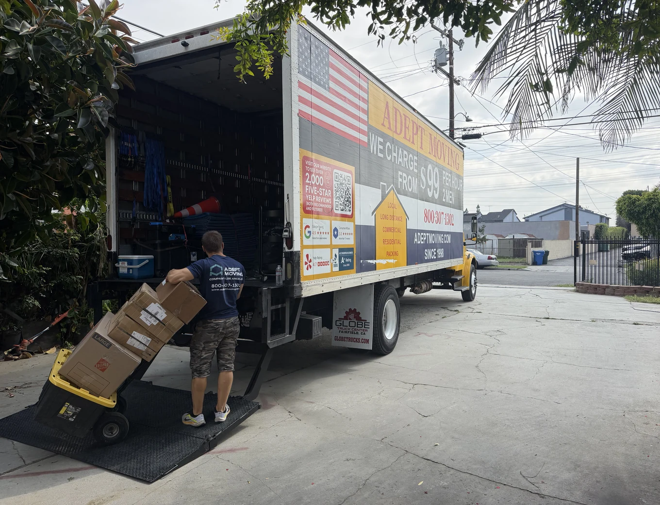 Adept mover with a dolly of boxes at the truck liftgate on Gundry Avenue in Paramount, 90723