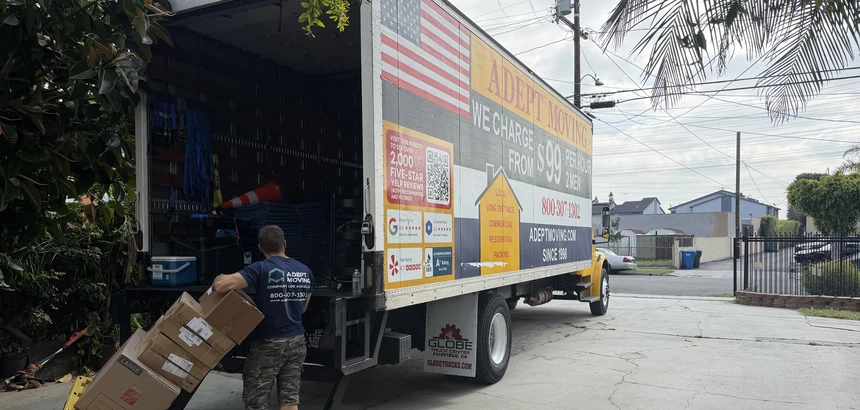 Adept mover with a dolly of boxes at the truck liftgate on Gundry Avenue in Paramount, 90723