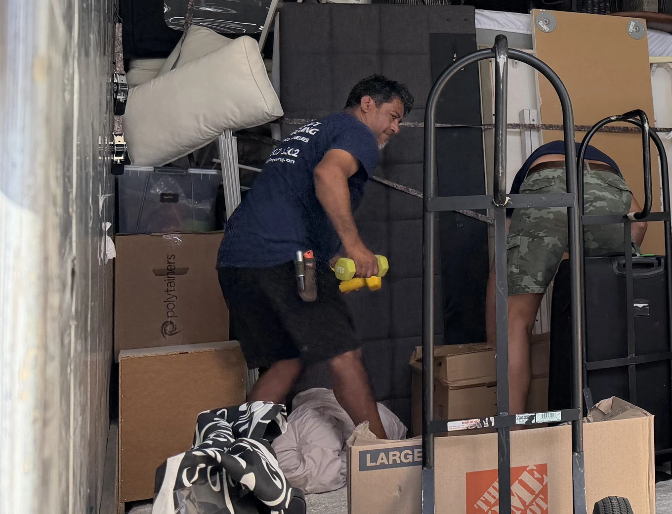 Adept mover moving packed boxes and a wrapped mattress on a hand truck on Industry Avenue in Pico Rivera, 90660