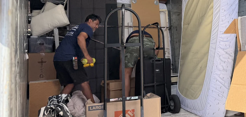Adept mover moving packed boxes and a wrapped mattress on a hand truck on Industry Avenue in Pico Rivera, 90660