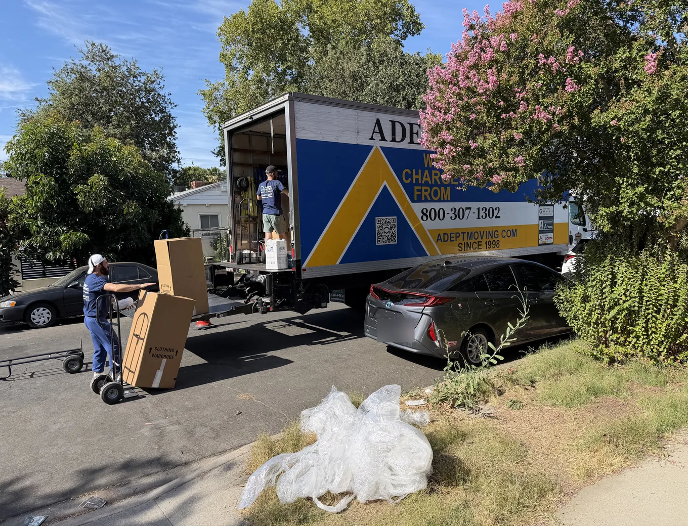 Adept Moving mover wheeling wardrobe cartons to the liftgate of the truck on Lull Street in Reseda, 91335