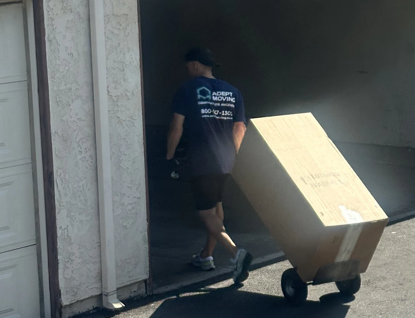 Adept mover moving a blanket-wrapped furniture piece on a hand truck in San Dimas, 91773