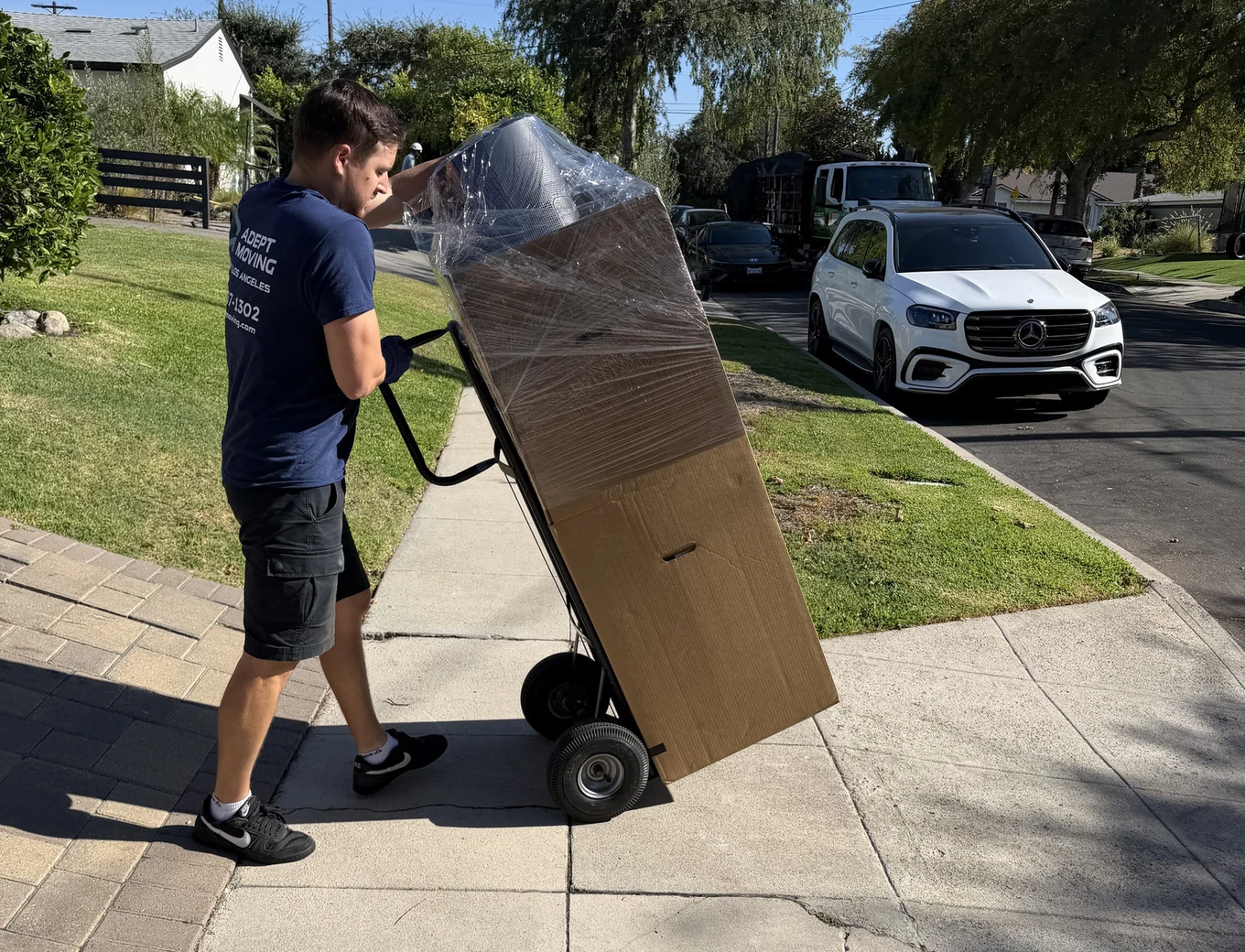Adept Moving mover with a wrapped dresser on a hand truck on Elmer Avenue in Studio City, 91602
