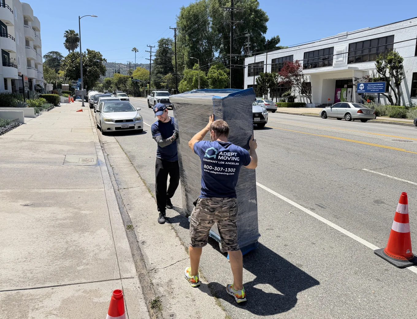 Adept Moving movers carrying shrink-wrapped furniture along Laurel Canyon Boulevard in Studio City, 91604