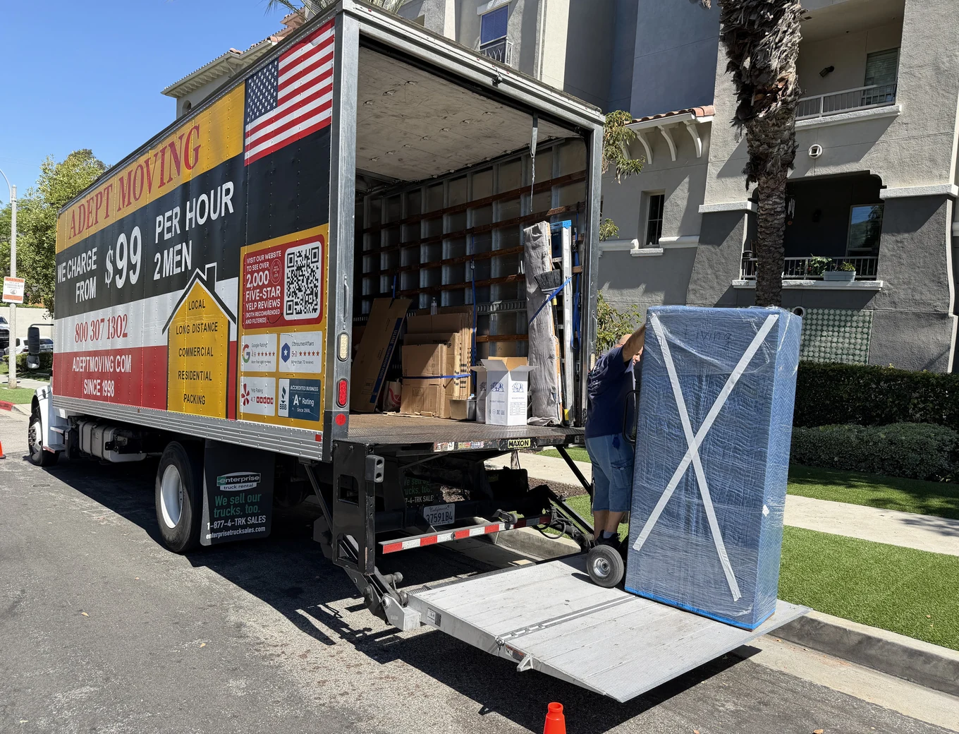 Adept Moving truck with the liftgate down at a condo building on Valleyheart Drive in Studio City, 91604