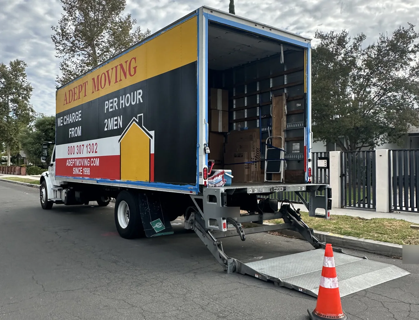 Adept Moving truck with the liftgate down at the curb on a residential street in Tarzana, 91356