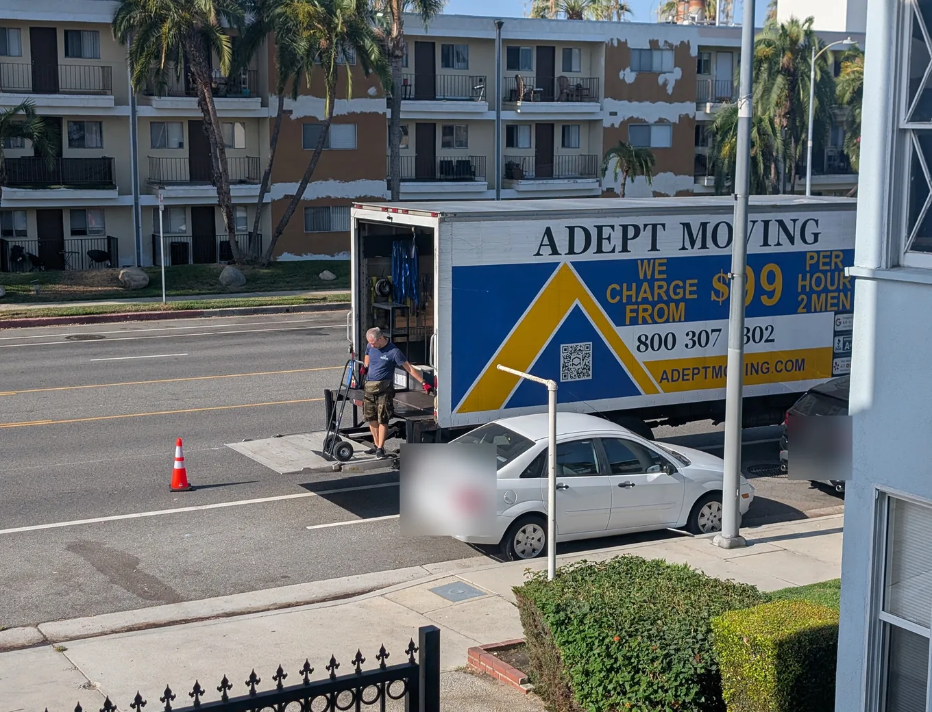 Adept Moving mover with a hand truck at the liftgate by an apartment building on Riverside Drive in Valley Village, 91607