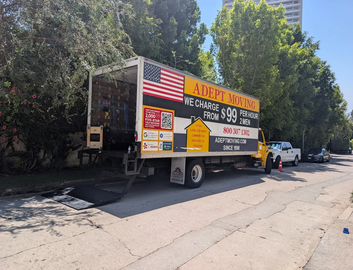 Adept Moving truck with the liftgate down on the narrow tree-lined Sierra Alta Way above the Sunset Strip