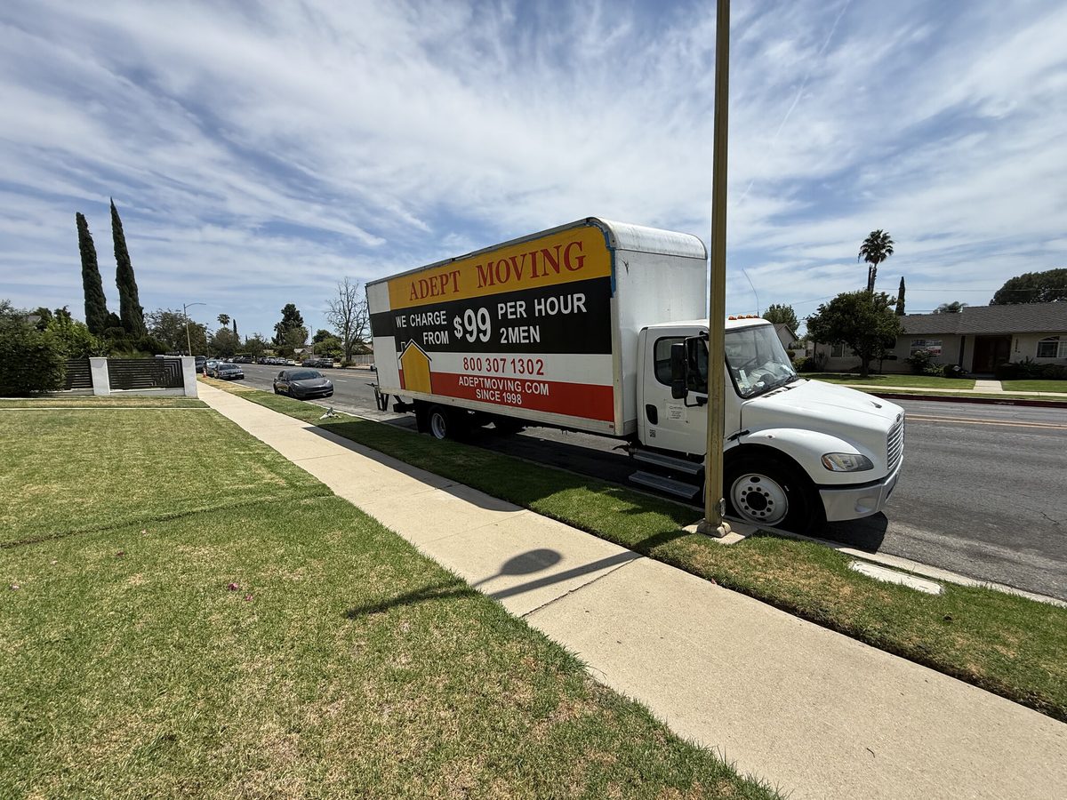 Adept Moving truck parked by a lawn on a residential street