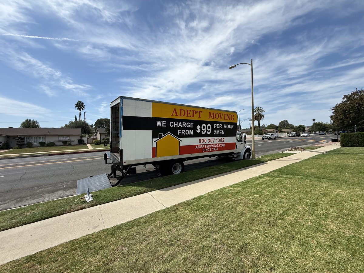Adept Moving truck with the liftgate down by the sidewalk