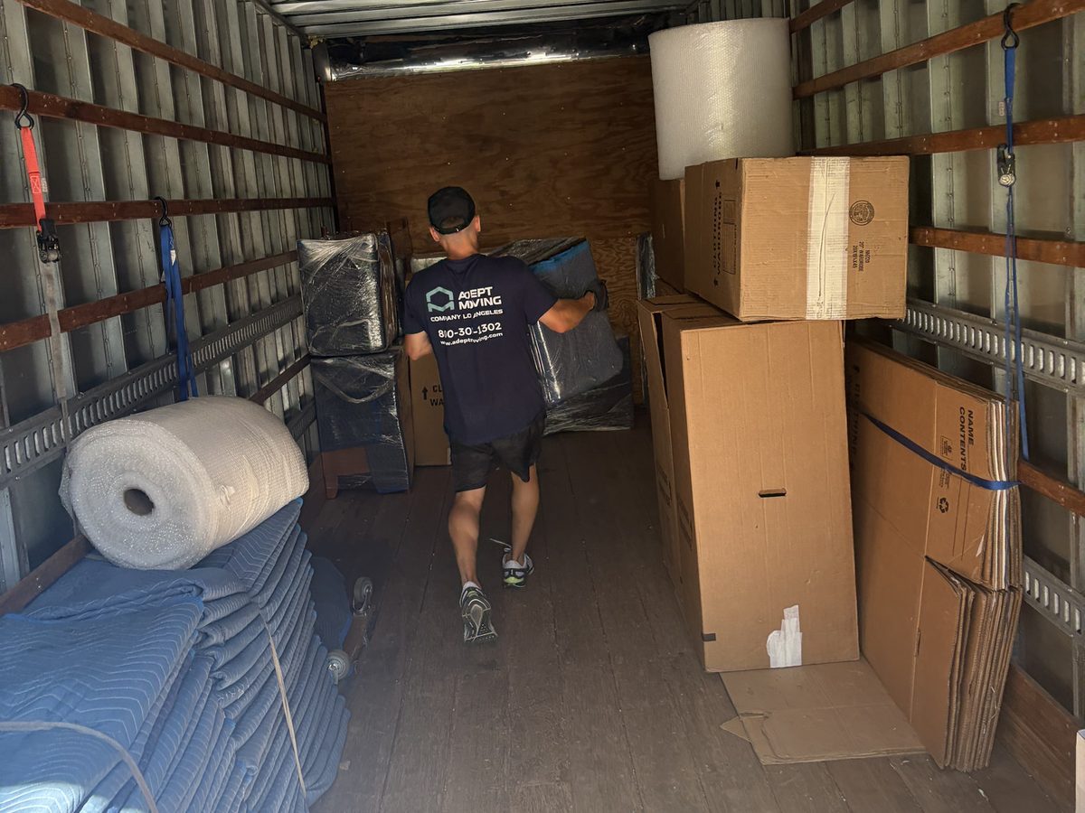 Adept Moving mover inside the 18-foot truck with boxes, moving blankets and a roll of wrap