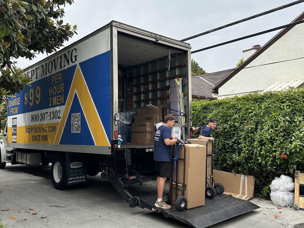 Adept Moving truck with the liftgate down behind an apartment building near Ocean Avenue