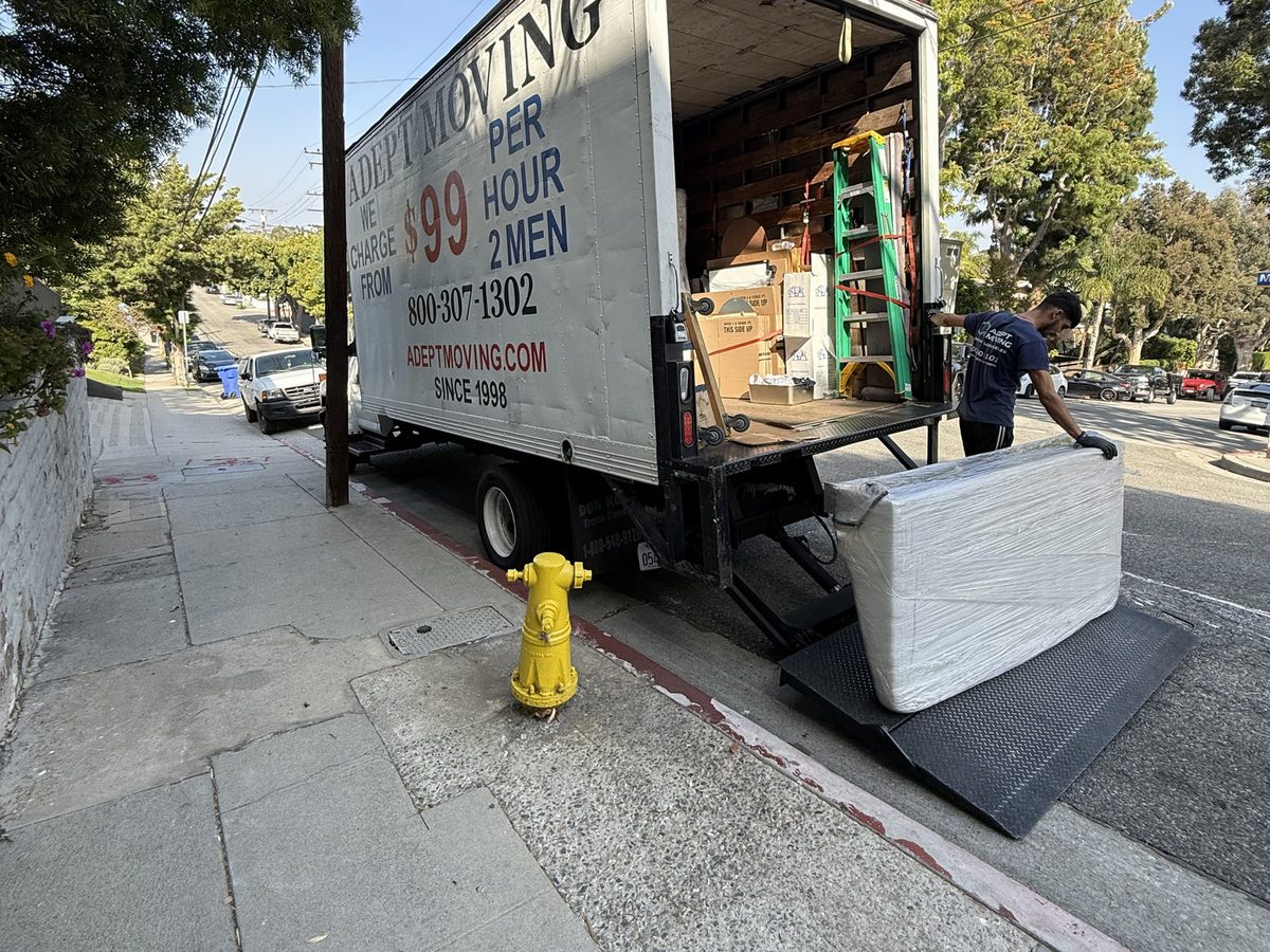 Adept Moving truck with the liftgate down beside a sloped sidewalk in Ocean Park