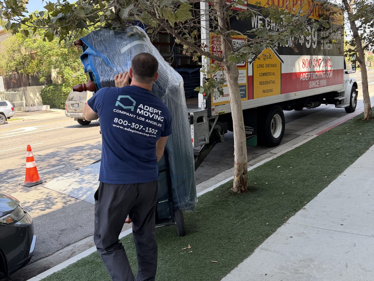 Adept Moving mover taking a blanket-wrapped piece along the parkway strip to the truck in Valley Village