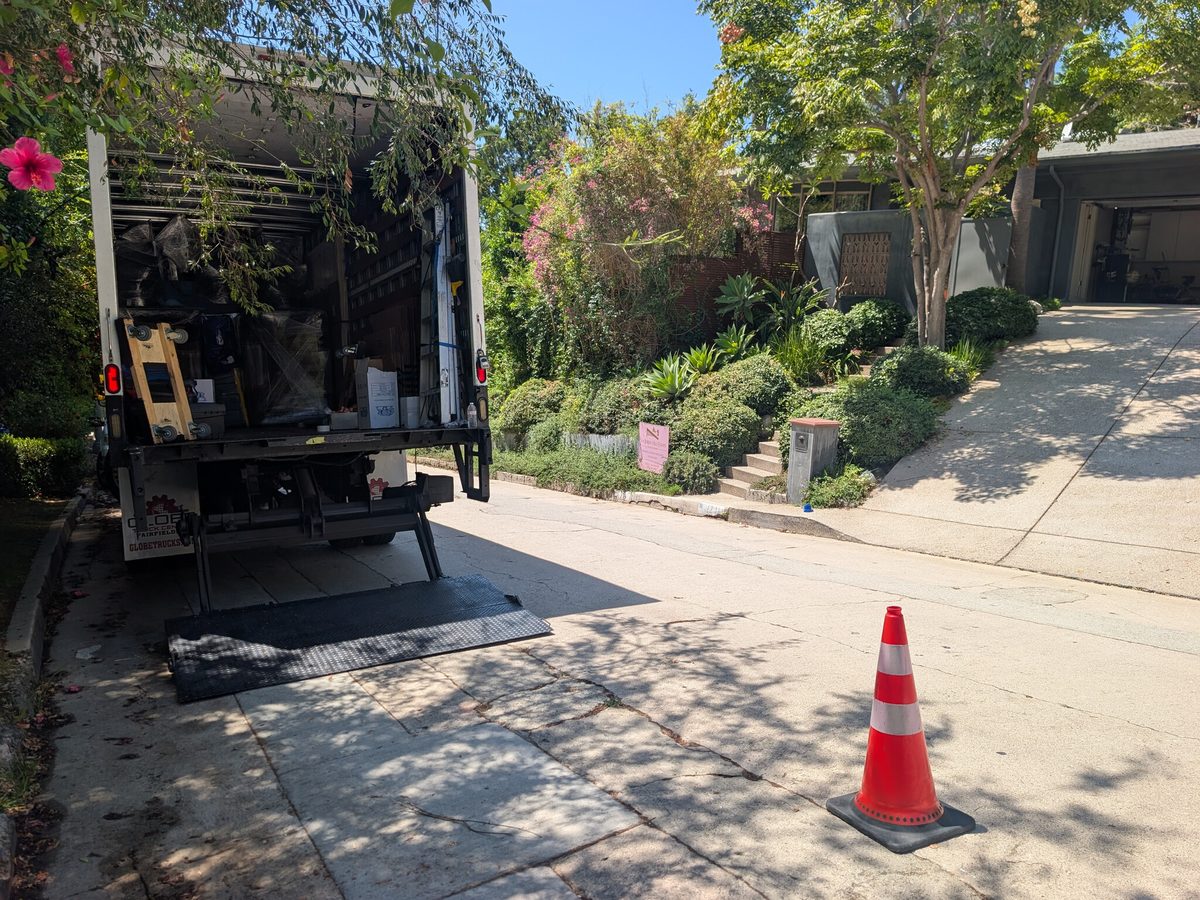 Adept Moving truck liftgate down with a cone set out at the curb on Sierra Alta Way