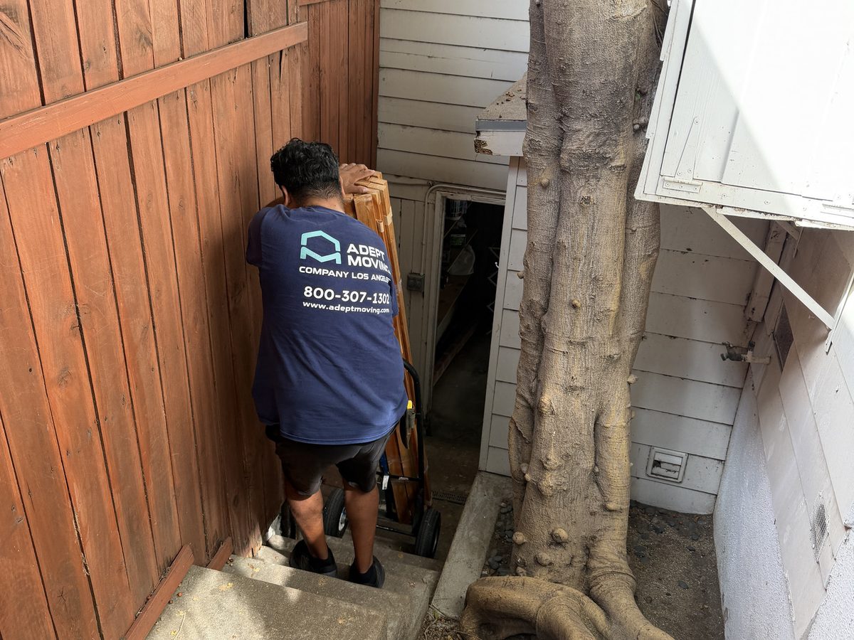Adept Moving mover carrying a piece through the narrow side passage beside the Queens Road house