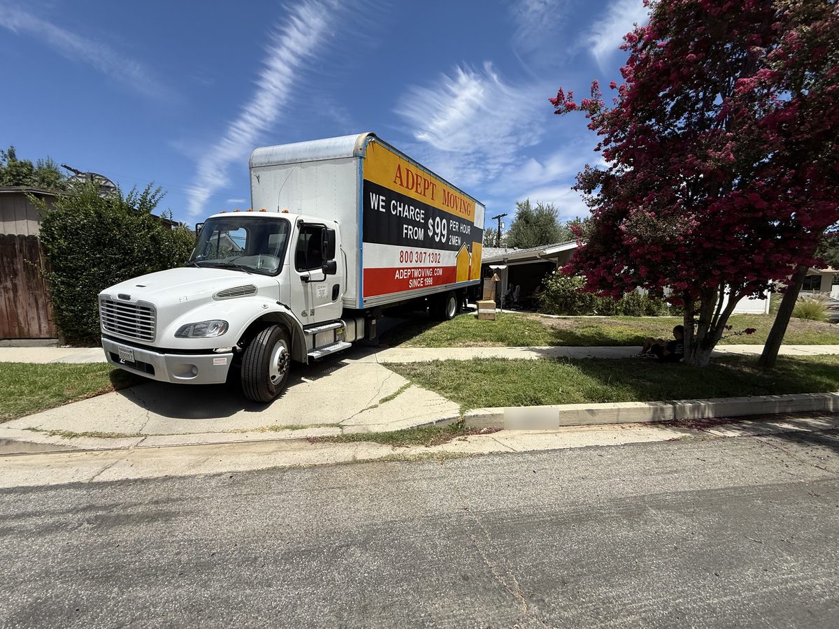Adept Moving truck backed up to the driveway of a ranch-style house on Keokuk Avenue