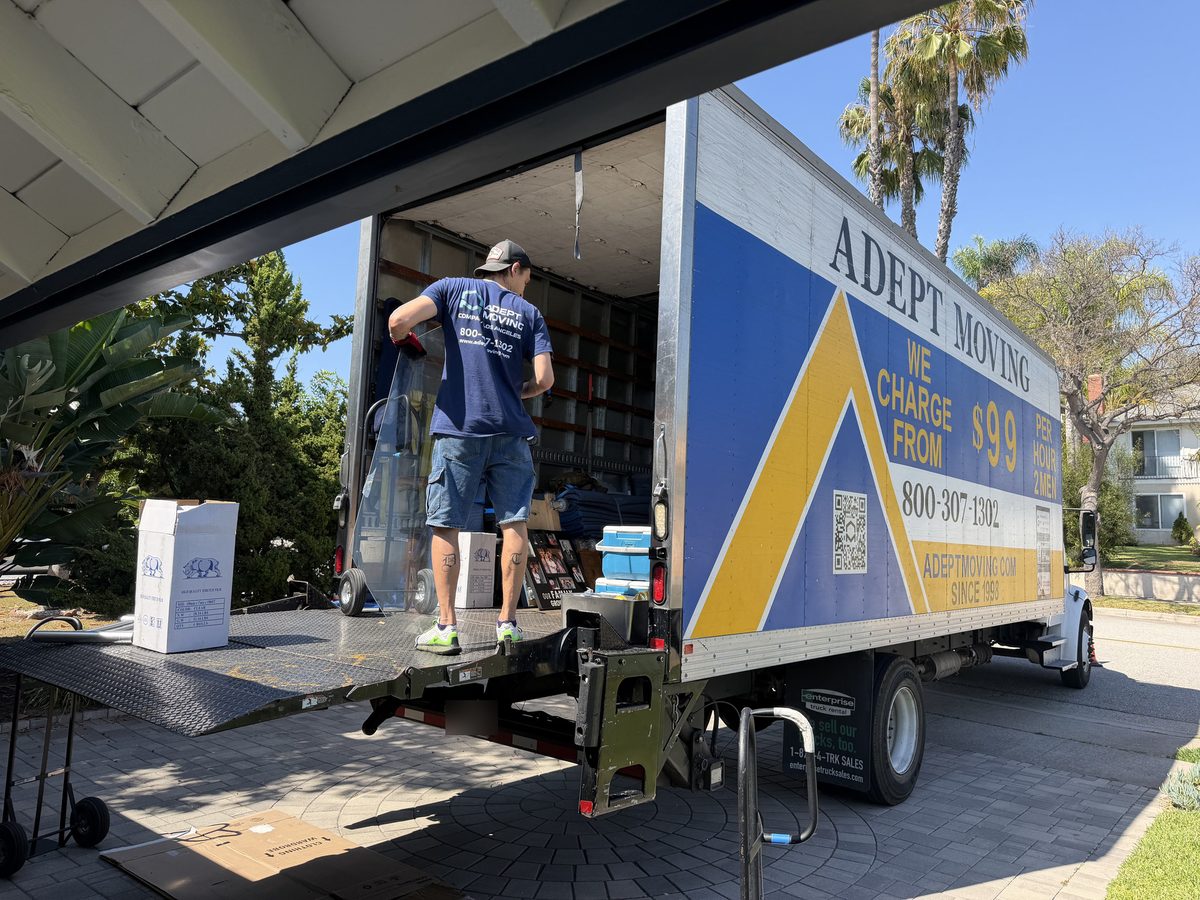 Adept Moving mover lifting a glass panel into the truck from the liftgate