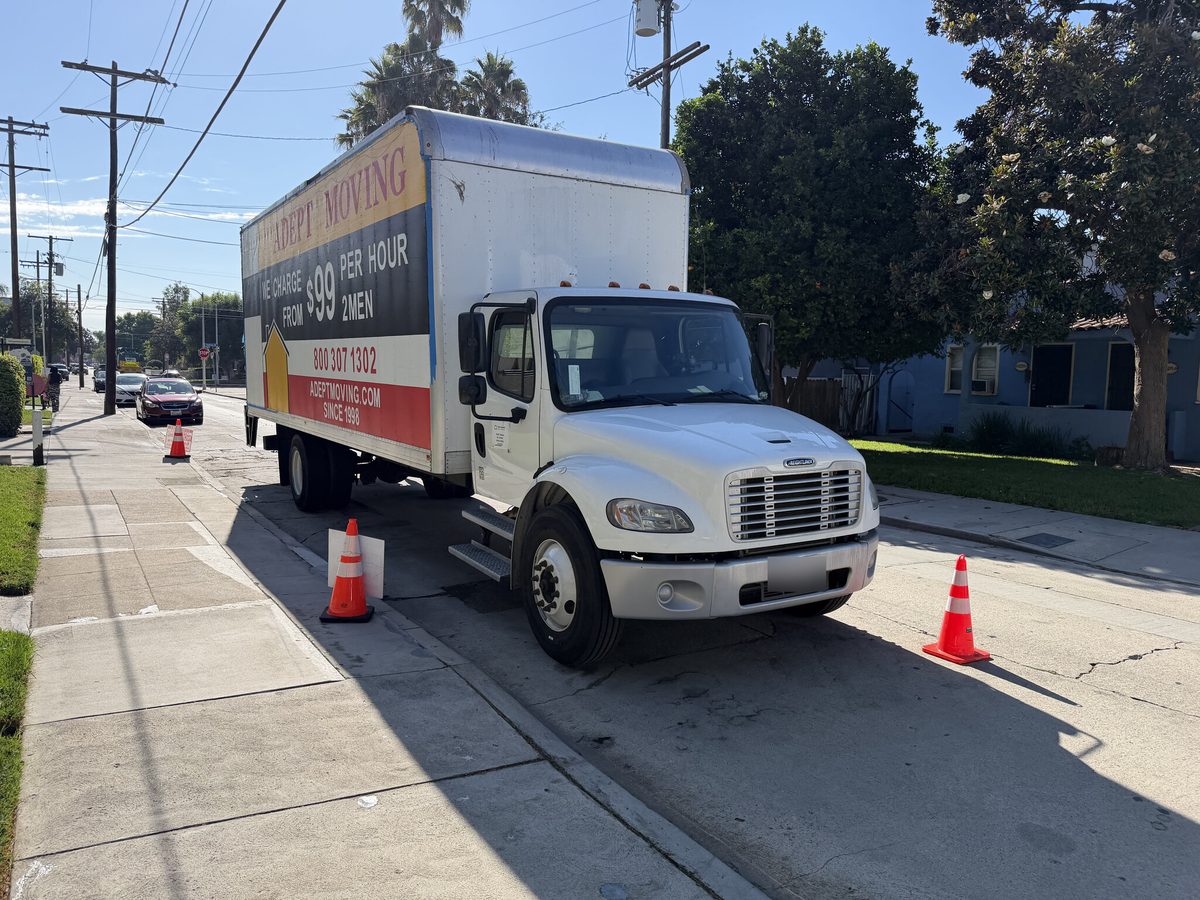 Adept Moving truck parked at the curb with safety cones in North Hollywood