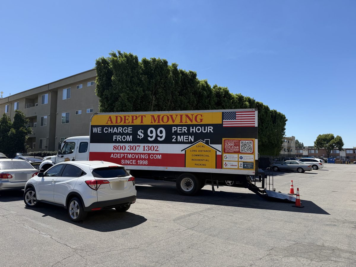 Adept Moving truck in the private parking lot of the garden-style apartment complex