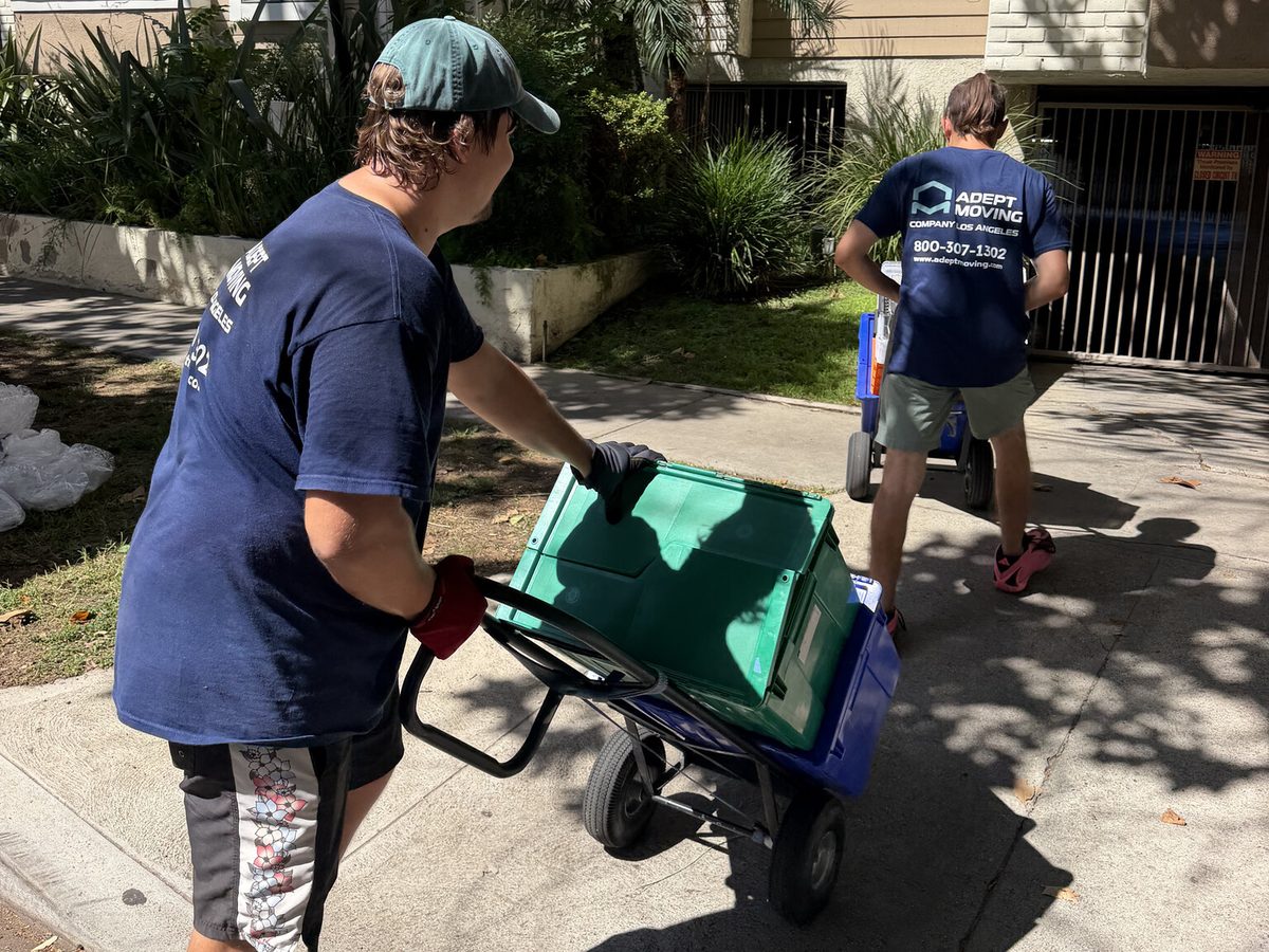 Adept Moving movers wheeling bins on hand trucks to the apartment building on Moorpark Street